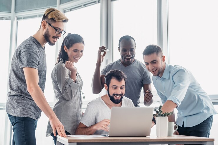 Gens d'affaires debout sur un ordinateur portable à table au bureau