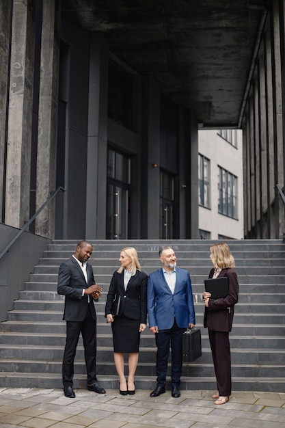 Gens d'affaires debout et se parlent devant un bureau moderne