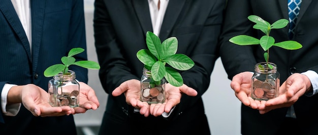 Photo gens d'affaires détenant un pot d'épargne rempli de pièces de monnaie et de plantes en croissance pour une planification financière durable pour la retraite ou un investissement de subvention écologique pour la protection de l'environnement