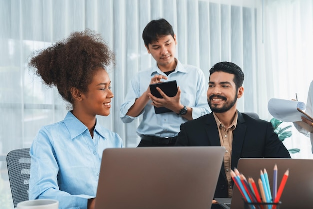 Des gens d'affaires divers et heureux travaillent ensemble pour discuter au bureau de l'entreprise Travail d'équipe professionnel et diversité discuter du plan d'affaires sur le bureau avec un ordinateur portable Employé de bureau multiculturel moderne Concord