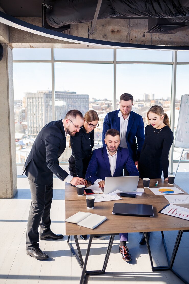 Photo des gens d'affaires heureux regardant la présentation d'un ordinateur portable, le succès au travail, assis dans un bureau moderne. négociations en ligne réussies. les hommes d'affaires partagent leurs connaissances