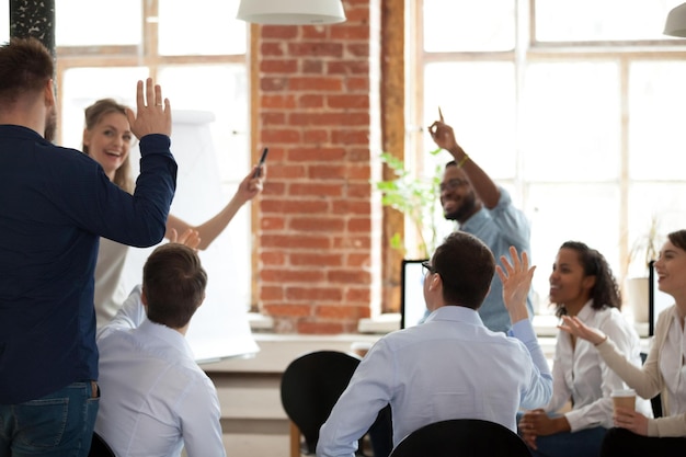 Gens d'affaires levant la main pour voter en posant des questions lors d'une conférence d'entreprise employés de formation pédagogique engagés dans le bénévolat lors d'une réunion de groupe coaching concept d'activité de teambuilding