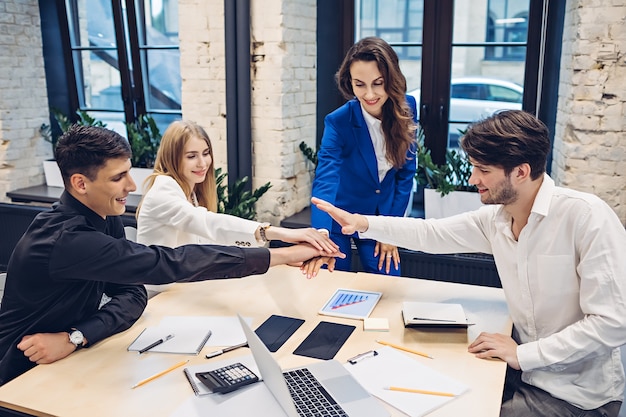 Gens d'affaires mettant les mains ensemble au bureau