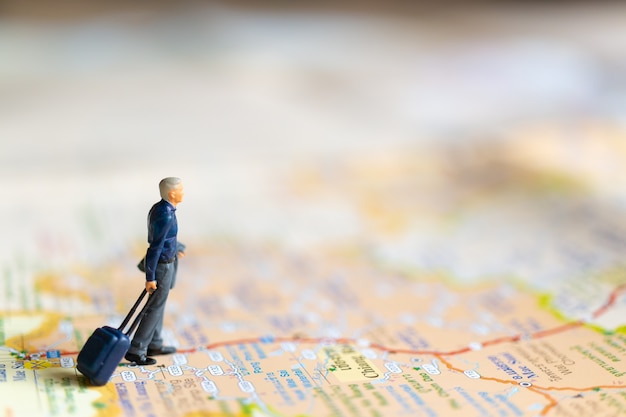 Gens d'affaires miniatures debout sur la carte, concept de voyage