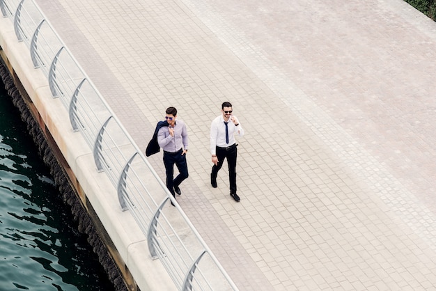 Les gens d'affaires en mouvement. Deux jeunes architectes prospères à Dubaï Marine marchant et regardant leurs nouveaux emplacements commerciaux.Vue de dessus.