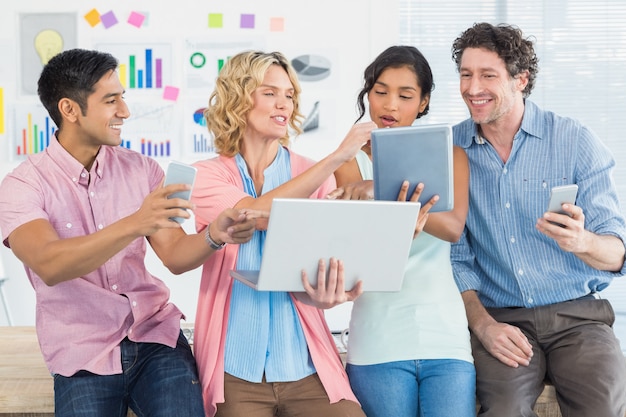 Des gens d&#39;affaires occasionnels utilisant une tablette numérique avec leurs collègues au bureau