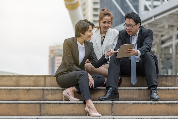 Les gens d&#39;affaires parler de plan de marketing financier dans le talet et s&#39;asseoir sur les escaliers