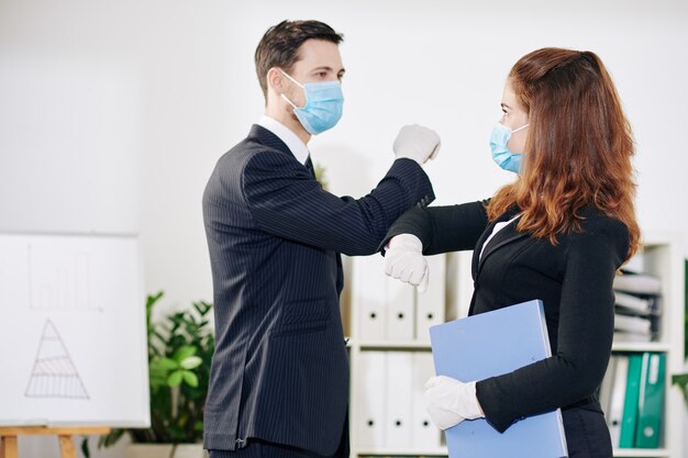 Des Gens D'affaires Portant Des Masques Médicaux Et Des Gants En Caoutchouc Faisant Une Bosse Au Coude En Raison D'une Pandémie De Coronavirus Lorsqu'ils Se Saluent Avant De Se Rencontrer