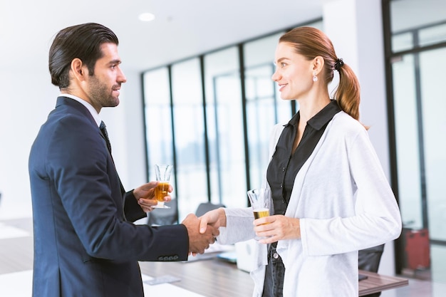 Les gens d'affaires réunis introduisent la poignée de main dans la fête de bureau de la boisson alcoolisée