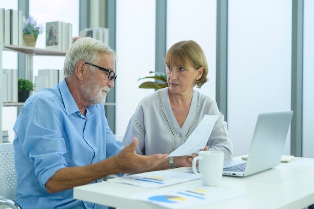 Gens d'affaires seniors caucasiens travaillant et remue-méninges dans un bureau moderne