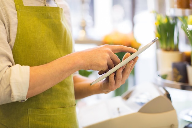 les gens, les affaires, la technologie, la vente et la fleuristerie et le concept - gros plan d'un homme fleuriste avec un ordinateur tablette au fleuriste