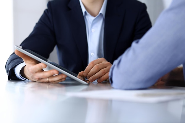 Gens d'affaires utilisant une tablette tout en travaillant ensemble au bureau dans un bureau moderne