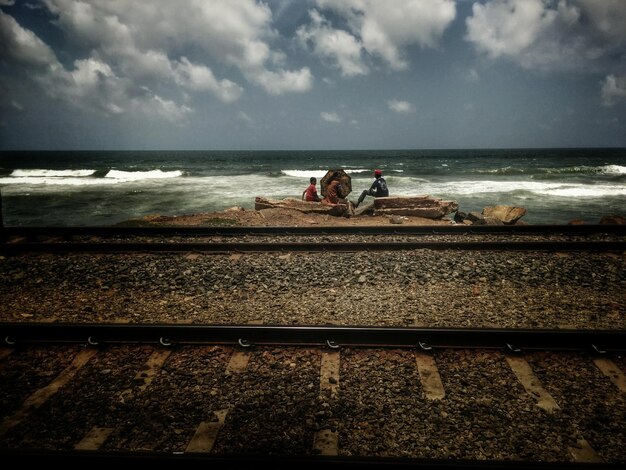 Photo des gens assis au bord de la mer