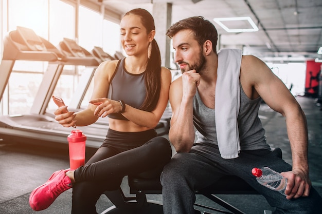 Photo les gens assis sur le banc de sport et se détendre après l'exercice