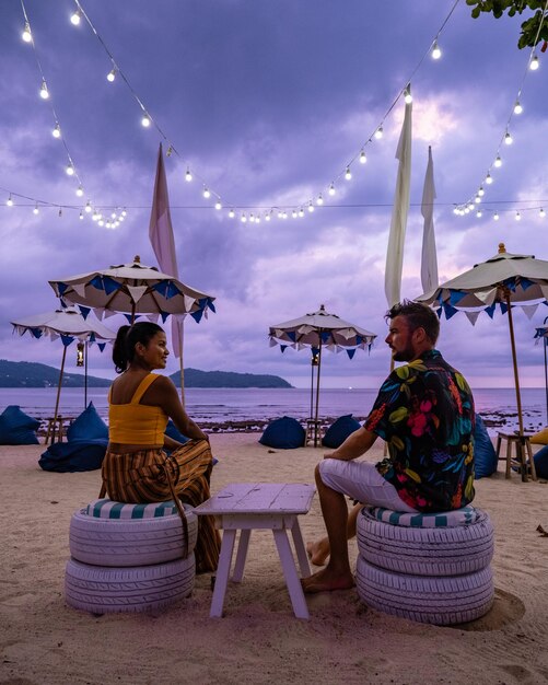 Des gens assis sur une chaise sur la plage contre le ciel