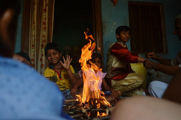 Des gens assis près du feu à la maison.