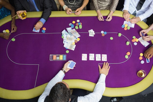 Les gens assis à table en jouant au poker