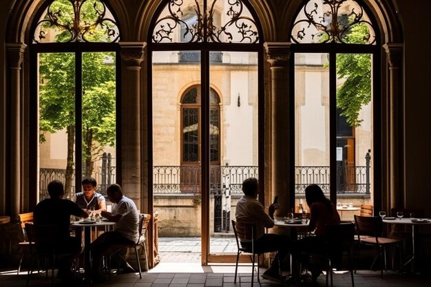 Photo des gens assis à des tables à l'extérieur d'un bâtiment avec une grande fenêtre