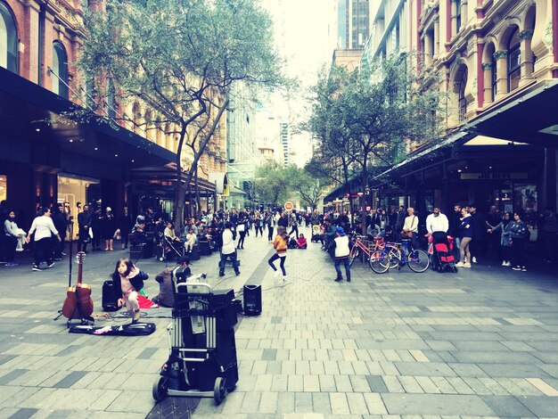 Photo des gens assis sur le trottoir en ville.