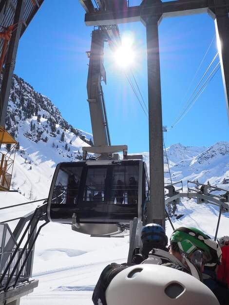 Photo les gens attendent la télésiège contre le ciel par une journée ensoleillée