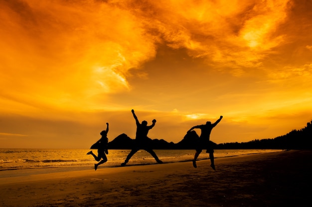 Gens au coucher du soleil sur la plage