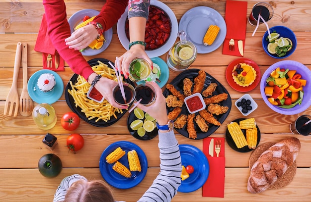 Les gens avec des boissons assis à la table à manger.