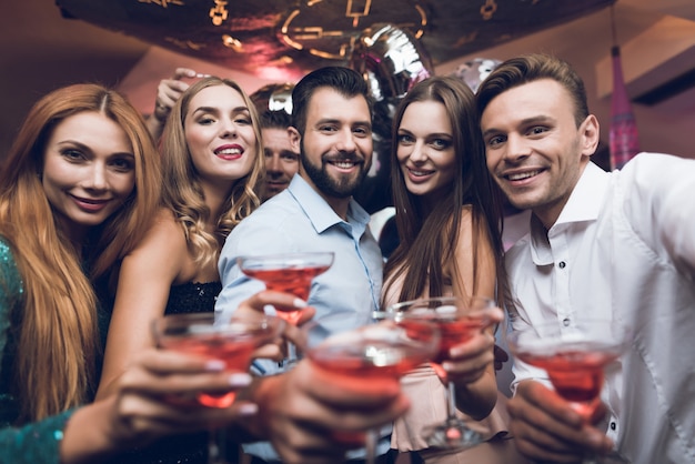 Les gens boivent des cocktails et s'amusent en boîte de nuit.