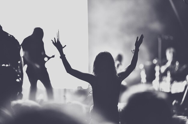 Les gens avec les bras levés font la fête au concert