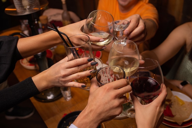 Gens de célébration tenant des verres de vin blanc faisant un toast