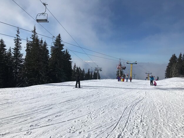 Photo des gens sur un champ couvert de neige contre le ciel