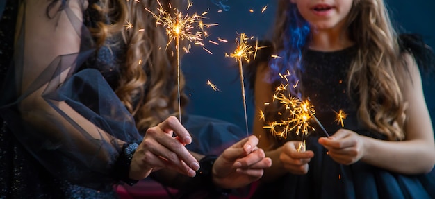 Les gens avec des cierges magiques sur fond de Noël. mise au point sélective. heureux.