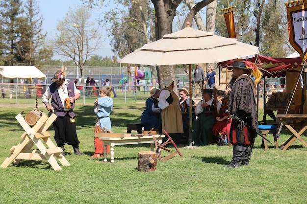 Des gens en costumes d'époque à une foire de la Renaissance