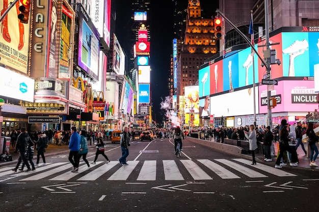 Photo des gens dans les rues de la ville la nuit.