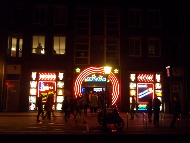 Photo les gens dans la ville éclairée la nuit