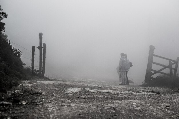 Photo des gens debout sur le champ par temps brumeux