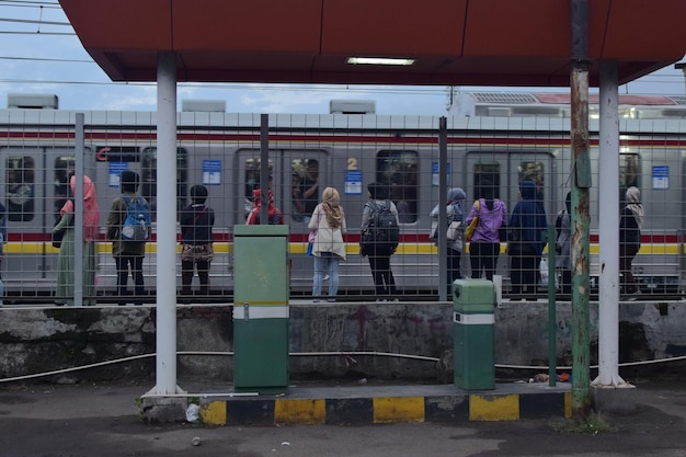 Photo des gens debout sur le quai de la gare.