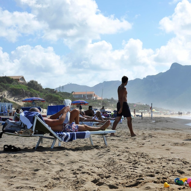 Des gens détendus sur la plage de Sabaudia pour les vacances d'été La montagne Circeo sur l'arrière-plan Sabaudia Lazio Italie