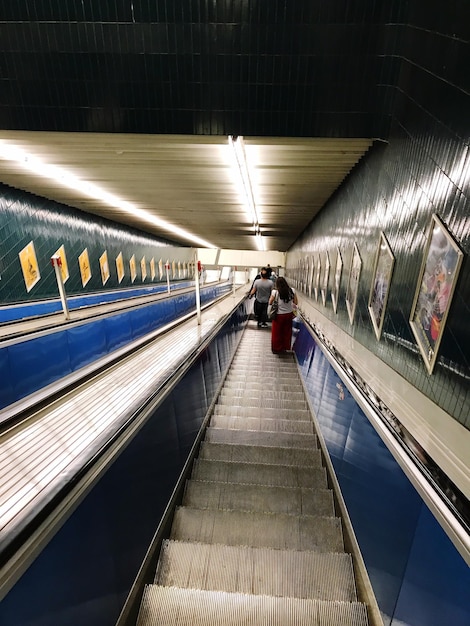 Photo des gens sur un escalier mécanique éclairé