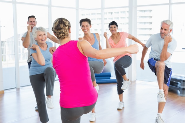 Gens, faire des exercices de remise en forme de puissance au cours de yoga dans un studio de fitness