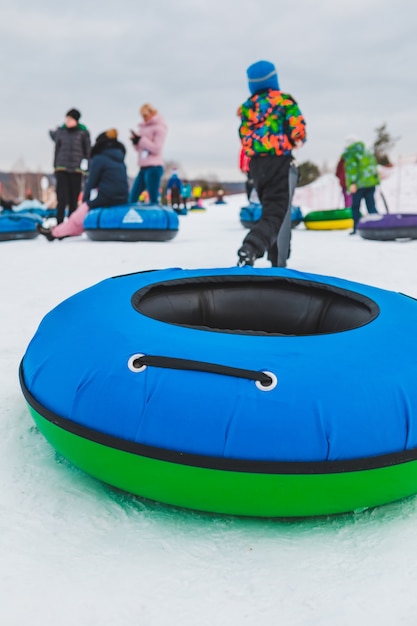 Les gens faisant du snow tubing à l'espace de copie du parc d'hiver