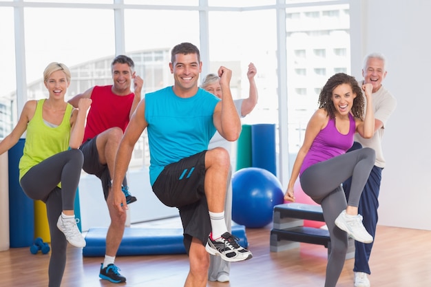 Gens faisant des exercices de remise en forme de puissance au cours de yoga