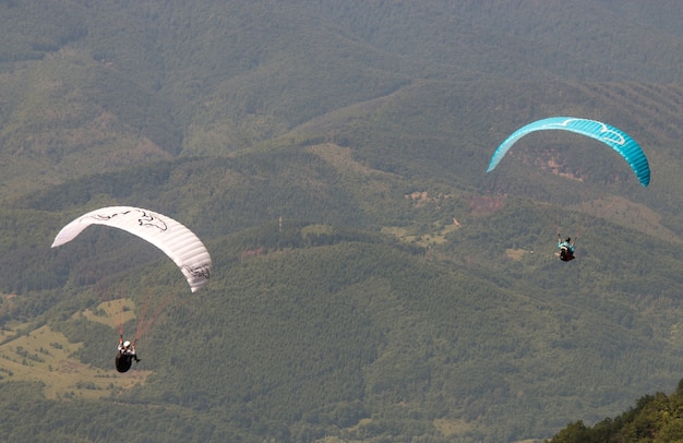 Les gens font du parapente sur de belles montagnes