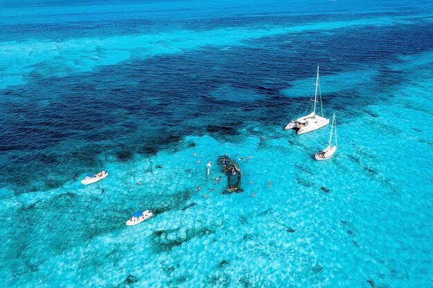 Les gens font de la plongée avec tuba autour de l'épave du navire près des Bahamas dans la mer des Caraïbes