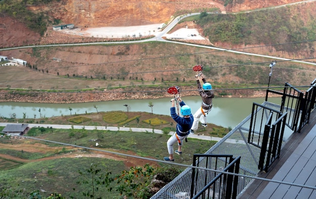 Des gens glissant sur une corde en l'air Photo