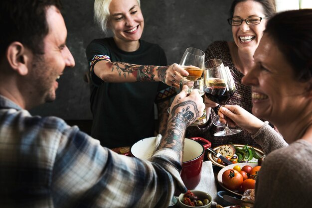 Gens heureux applaudissant avec des verres de vin