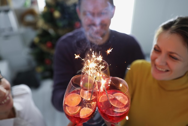 Des gens heureux lèvent des verres de champagne dans l'air et disent des toasts