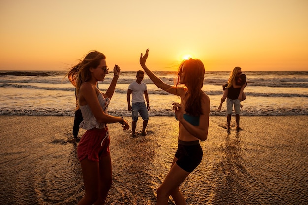Des gens heureux multiculturels multinationaux qui courent au soleil sans soucis et des vacances de bonheur en mer