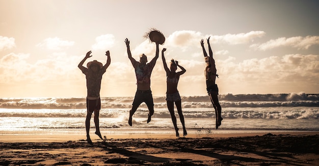 Les gens heureux sautent de joie et de bonheur pendant les vacances d'été à la plage