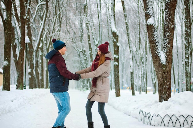 Gens, jeune couple marchant, dansant dans le parc. Vacances d'hiver en famille, convivialité, rendez-vous. Aimer