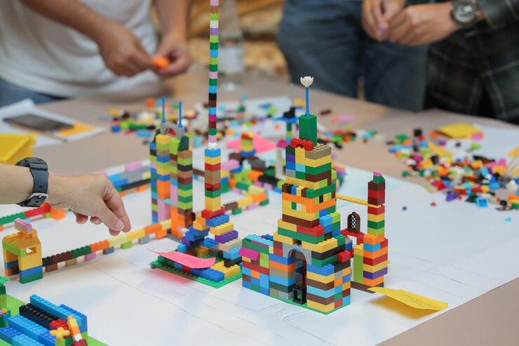 Photo des gens jouant avec des blocs de jouets sur la table.